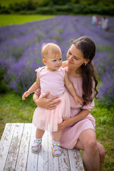 Fototapeta premium Mother with her little daugher on lavender field background in Czech republic