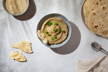 Baba ghanoush, babaganush or baba ganoush in gray bowl served with  oriental flatbread on concrete background. Turkish cuisine. Top view.
