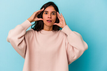 Young caucasian woman isolated on blue background receiving a pleasant surprise, excited and...