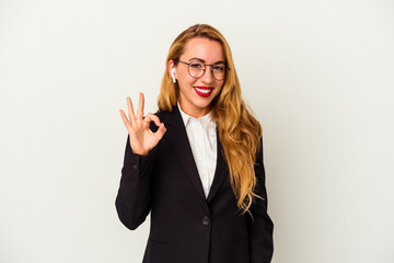 Caucasian business woman wearing a wireless headphones isolated on white background cheerful and confident showing ok gesture.