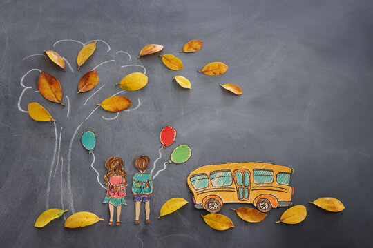 Back to school concept. Top view banner of school bus next to tree sketch with autumn dry leaves and kids over classroom blackboard background
