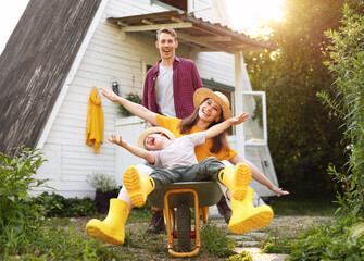 Excited family playing with wheelbarrow