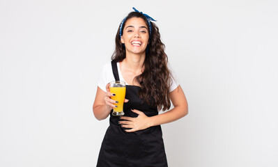 pretty woman laughing out loud at some hilarious joke and holding an orange juice glass