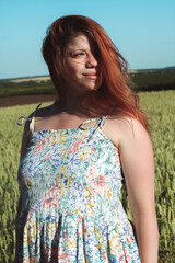 
A pregnant girl in a field with wheat looks natural and beautiful