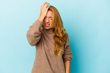 Caucasian woman isolated on blue background forgetting something, slapping forehead with palm and closing eyes.