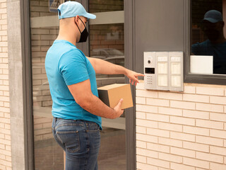 Caucasian man in uniform of postman or courier delivery man or parcels entering door and streets