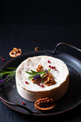 Food concept organic soft creamy cheese French Camembert on black background with copy space