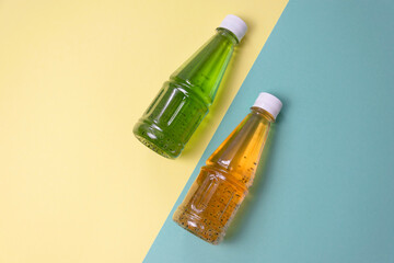 Kiwi juice and mango juice in clear plastic bottles