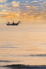 Imbarcazione sul mare all'alba