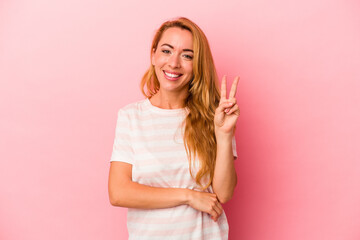 Caucasian blonde woman isolated on pink background showing number two with fingers.