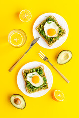 Fototapeta na wymiar Open sandwich with eggs and avocado on plate. Overhead view