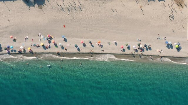 Vista verticale di una spiaggia con ombrelloni e sabbia