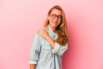 Caucasian blonde woman isolated on pink background having a shoulder pain.