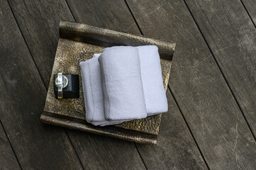 Concept Spa : Top view of Spa set white Towels with bottle cream pump put on wooden floor.