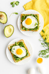 Toasts with eggs and avocado cream and spinach. Top view