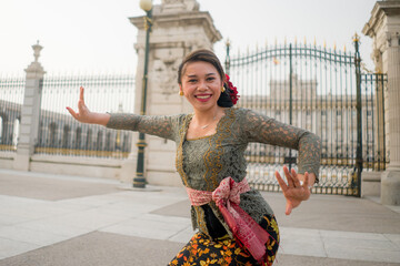 Fototapeta na wymiar young happy Indonesian woman from Bali having vacation in Europe - attractive and cheerful Balinese tourist girl in traditional outfit touring in the city enjoying holidays trip
