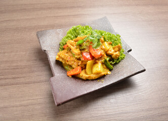 asian stir fried yellow turmeric curry chicken with vegetables on wood background Thai halal menu