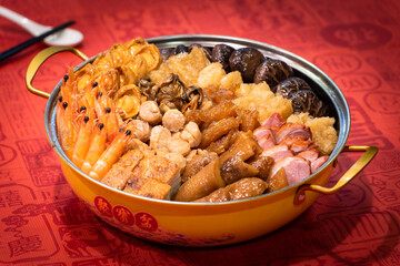 chinese traditional Peng cai with luxury seafood, meat, vegetable and premium sauce in hot pot in red chinese new year background asian halal menu