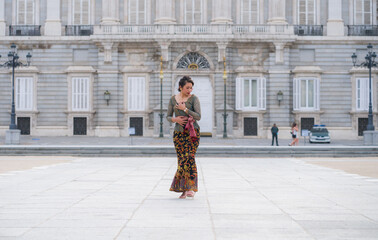 Fototapeta na wymiar young happy Indonesian woman from Bali having vacation in Europe - beautiful and exotic Balinese tourist girl dancing in traditional outfit touring in the city enjoying holidays