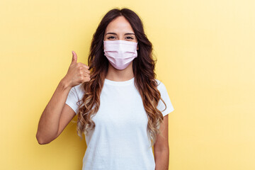 Young mixed race woman wearing a protection for virus isolated on yellow background Young mixed race woman wearing a protection for virus isolated on yellow background smiling and raising thumb up