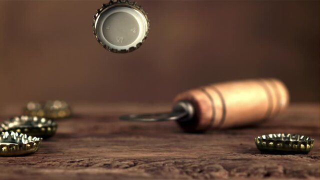 The super slow motion lid from the beer bottle falls on the table and spins. On a brown background.Filmed on a high-speed camera at 1000 fps.