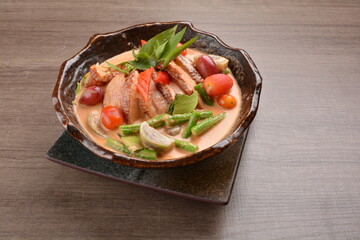 thai red curry hot spicy soup with duck or chicken with vegetables on wood background asian halal menu