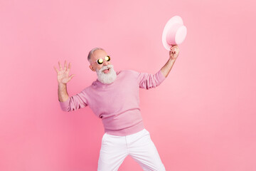 Photo of optimistic grey hair old man dance look empty space wear eyewear cap sweater isolated on pink background