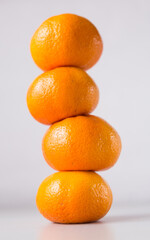 tower of four mandarines on white background