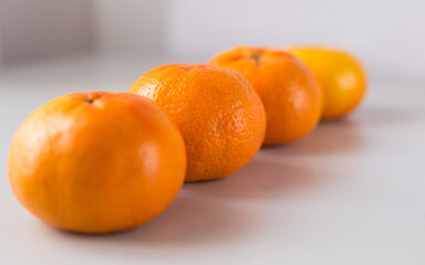 appetizing tangerines laid out in a row on white background