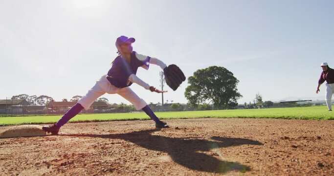 Diverse female baseball players, fielder on base catching out a running hitter on baseball field