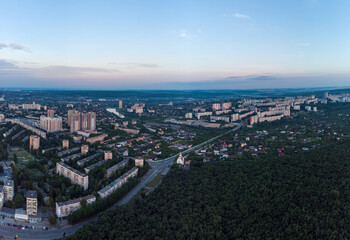 Fototapeta na wymiar Aerial morning view Kharkiv city Pavlove Pole district Derevianka St. Multistory buildings near forest with scenic blue sky in summer dawn light