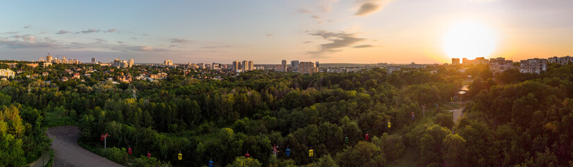 Sarzhyn Yar with cable car attraction aerial view in green summer Kharkiv city popular recreation Central Park. Recreation area in city center in sunset wide panorama
