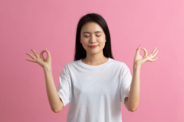 Portrait of asian woman with hand okay gesturing, isolated on pink.