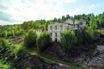 Fototapeta na wymiar an abandoned mine in the woods. old ruined building in nature, aerial view drone