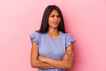 Fototapeta premium Young latin woman isolated on pink background frowning face in displeasure, keeps arms folded.