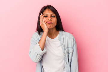 Young latin woman isolated on pink background who feels sad and pensive, looking at copy space.