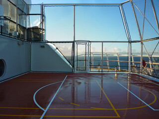 Basketball-Spielfeld in Sportkomplex auf Kreuzfahrtschiff mit blauem Himmel und Wolken nach Regen ...