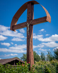 A christian wooden wayside cross in Strzegomiany, Poland. Blue sky, sunny day.