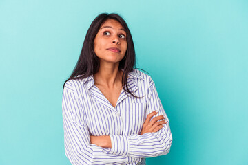 Obraz premium Young latin woman isolated on blue background dreaming of achieving goals and purposes
