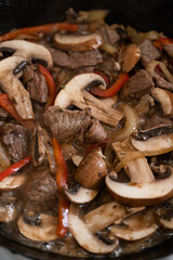 Vertical shot of frying pan with meat and portobello meal