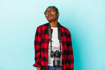 Young photographer african american woman isolated on blue background dreaming of achieving goals and purposes