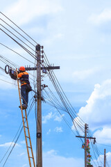Fototapeta na wymiar Low angle view of technician on wooden ladder checking fiber optic cables in internet splitter box on electric pole against white cloudy in vertical frame