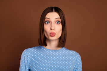 Photo of flirty brunette young lady blow kiss wear dotted shirt isolated on brown color background