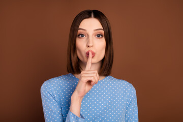 Photo of brunette millennial lady finger mouth wear dotted shirt isolated on brown color background