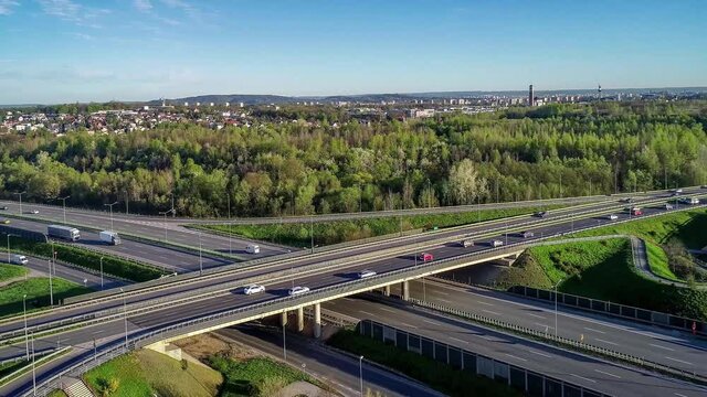Motorway multilevel crossing. Spaghetti junction on A4 international highway, the part of orbital road around Krakow, Poland. Aerial 4K panning video in spring.