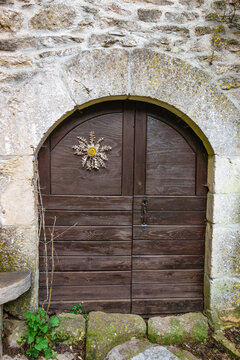 Carlina, carline, cardabelle, lucky charm thistle serving as barometer on wooden door, templar village of Causses, La Couvertoirade, Aveyron, France