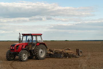 Obraz premium small red farm tractor on the field