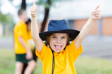 Happy Australian school girl with thumbs up and tongue out