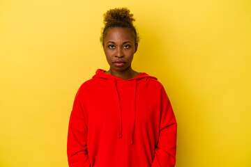 Young african american woman isolated on yellow background sad, serious face, feeling miserable and...