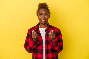 Young african american woman isolated on yellow background showing that she has no money.